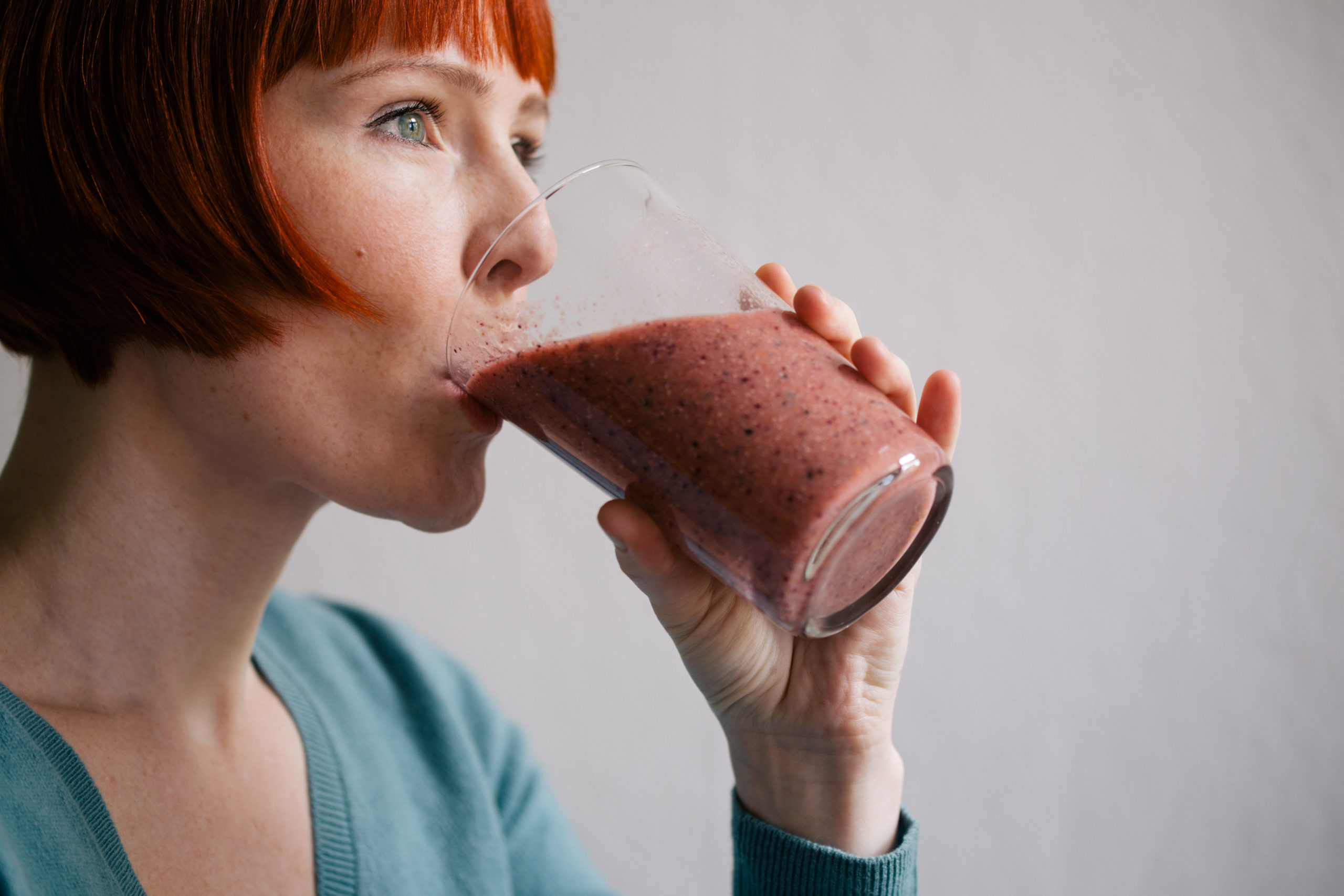 red-haired-woman-drinking-smoothie-QH259ZS