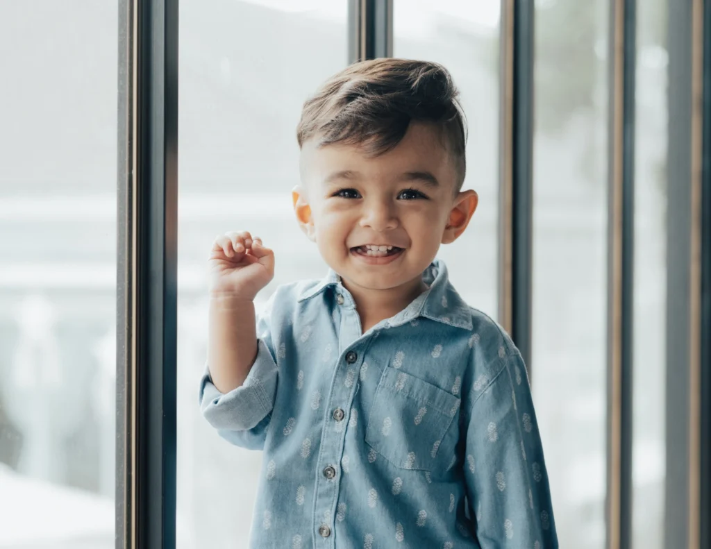 Young child standing in front of big windows