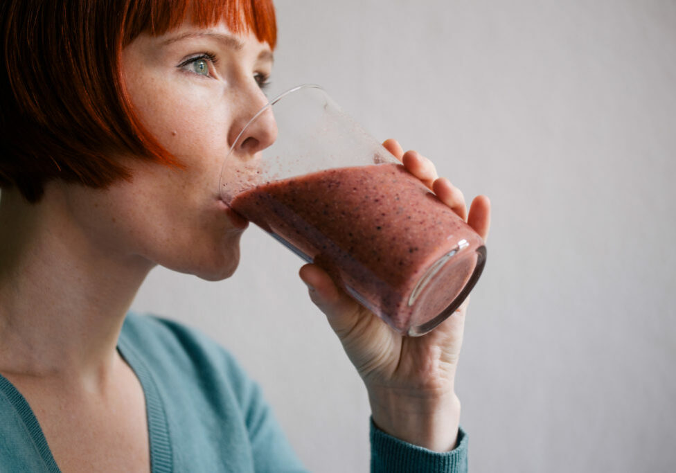 red-haired-woman-drinking-smoothie-QH259ZS